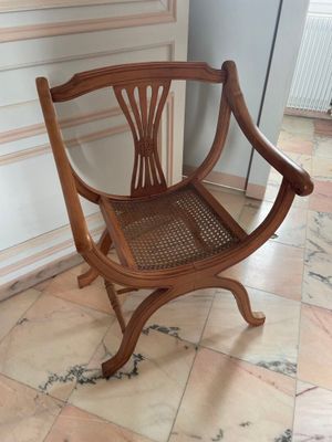a wooden chair that is sitting on a tile floor