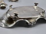 a silver tray that has a bunch of silver objects on it