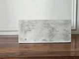 concrete block sitting on a wooden table in front of a white wall