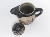 a small cup with a lid sitting on a table