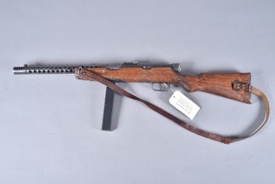 an old rifle with a wooden handle on a white surface
