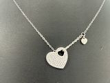 a necklace with a heart and a key on a mannequin mannequin