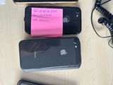 several cell phones are lined up on a table with a notepad attached to them