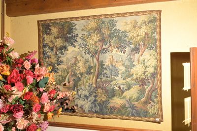 un vase de fleurs devant un tableau accroché au mur