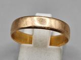 gros plan d'une bague en or sur une surface blanche