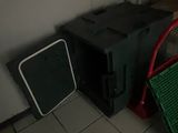 a green crate and a black box sitting on the floor