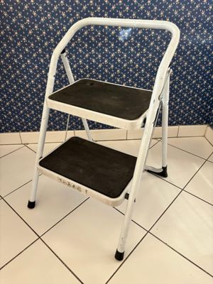 two step stools in a bathroom with blue and white wallpaper