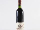 a bottle of red wine sitting on top of a white table