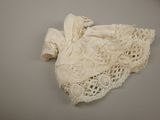 a white dress with lace on it laying on a table