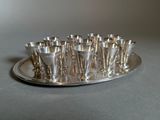 a silver tray with silver cups on it on a table