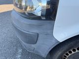 a close up of a car ' s front bumper with a reflection of a building in the mirror
