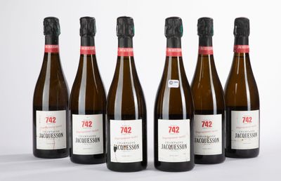 six bouteilles de vin sont alignées sur une surface blanche