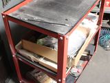 a red work cart with tools on it in a garage