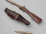 trois types d'armes différents sont exposés sur une surface blanche