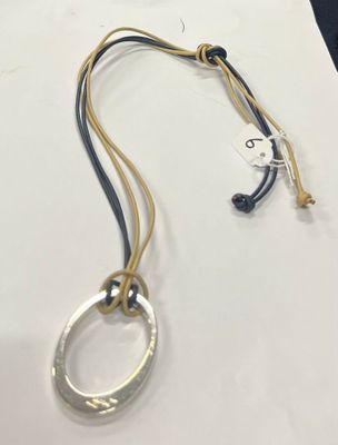 un gros plan d'un collier posé sur une table, à côté d'un bout de papier