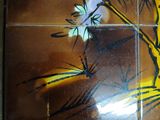 a tile with a picture of a tree and flowers on it