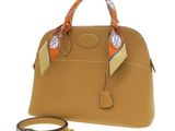 a close up of a handbag with a scarf on it