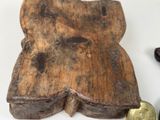 a small wooden object on a table next to a coin