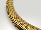 a close up of a gold necklace on a white surface