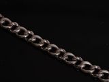 a close up of a silver chain on a black surface