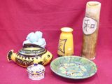 a red table cloth with a bowl, vase, and other items on it