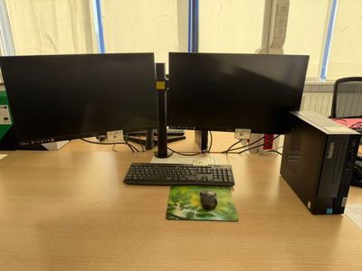 two computer monitors and a keyboard on a desk