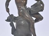 statue en bronze représentant un homme assis sur un rocher, tenant un livre