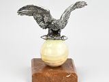 une image représentant une statue d'aigle posé sur une sphère