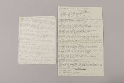 two pieces of paper with writing on them sitting on top of a table