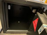 a black metal safe box with a red sticker on it