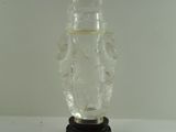 a clear glass vase with a black base on a white table