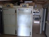 several refrigerators and freezers are lined up in a room