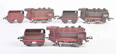 quatre petits trains miniatures posés sur une surface blanche