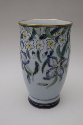 un vase blanc orné de fleurs bleues et jaunes