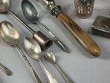 a lot of silver spoons and other silverware on a table