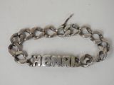 a close up of a silver bracelet with a name on it