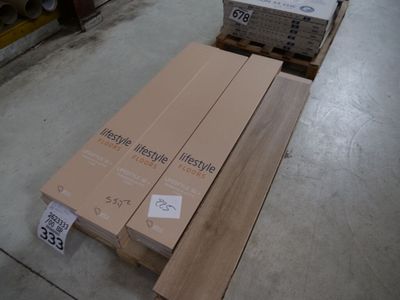 Plusieurs caisses en bois sont empilées sur une palette dans un entrepôt