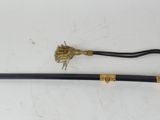 an old sword with a gold handle sitting on a white surface
