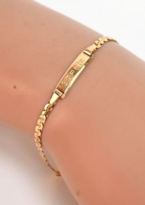 un gros plan sur le bras d'une personne portant un bracelet en or