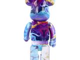the bear is wearing a tie dye shirt and standing on a white surface