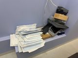 a pile of mail sitting on a shelf in a room