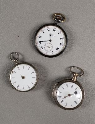 Trois types différents de montres de poche sont exposés sur un fond gris