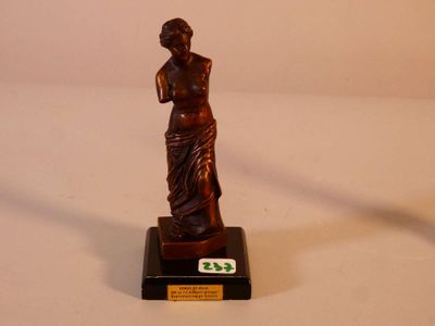 une statue en bronze représentant une femme tenant une raquette de tennis