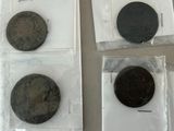 four different types of coins in plastic bags sitting on a table