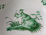 a green and white plate with a frog on it