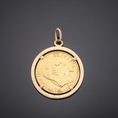 un pendentif en forme de pièce d'or sur lequel est gravé le portrait d'un homme