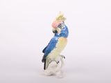 une figurine représentant un perroquet perché sur une branche