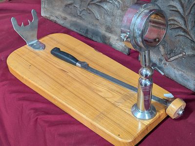 une planche à découper en bois sur laquelle sont posés un couteau et un coupe-fromage