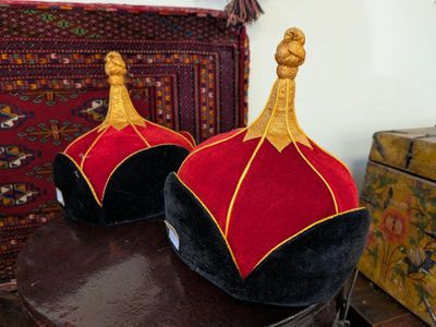 pair of red and black hats on top of a wooden table