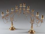 pair of antique brass candelabs with candles on each of them